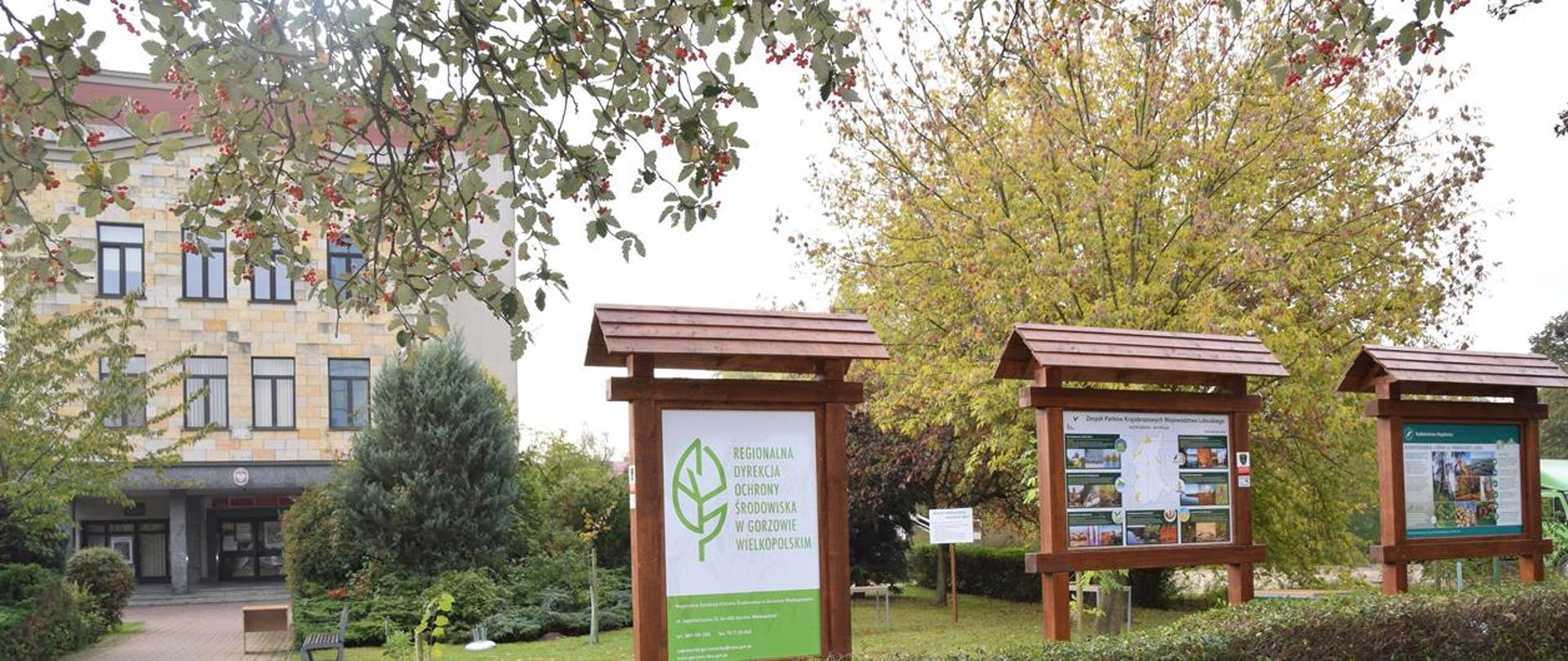 Na zdjęciu siedziba RDOŚ, skwerek a na nim tablice, sadzonki drzew, ławki, ptasia budka i tablica kwietna łąka