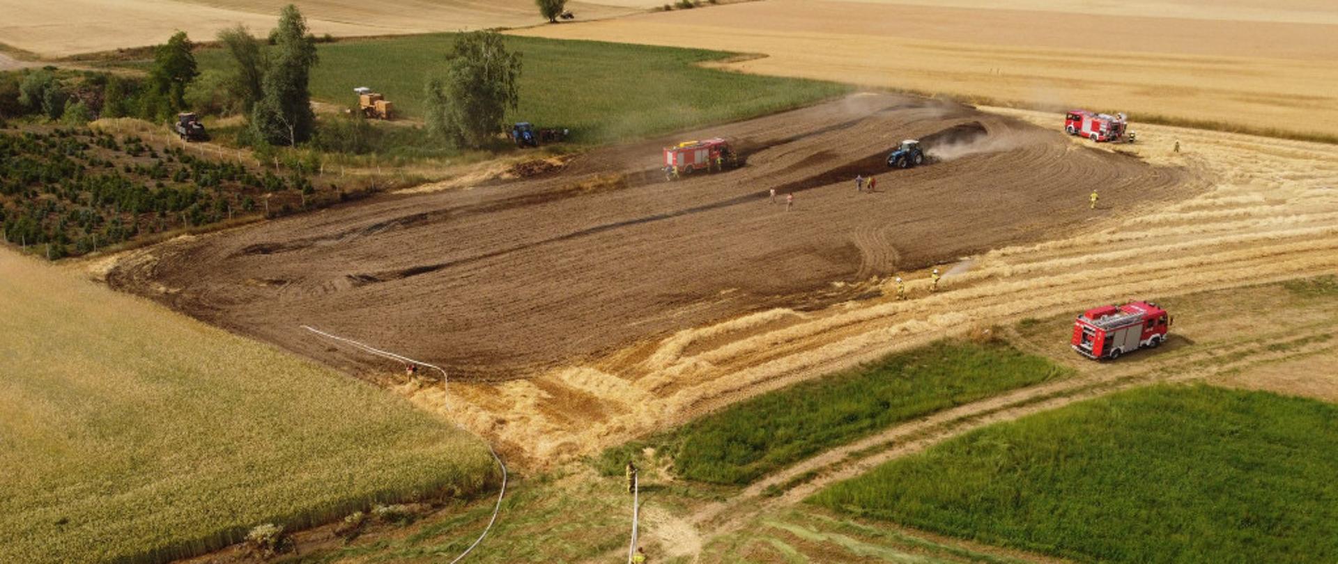 Zdjęcie przedstawia zastępy straży działające na polu.