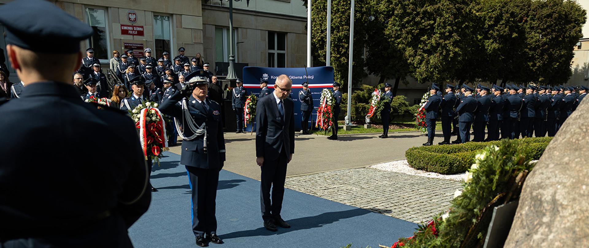 Na zdjęciu wiceminister Błażej Poboży składa wieniec przy obelisku przed KGP