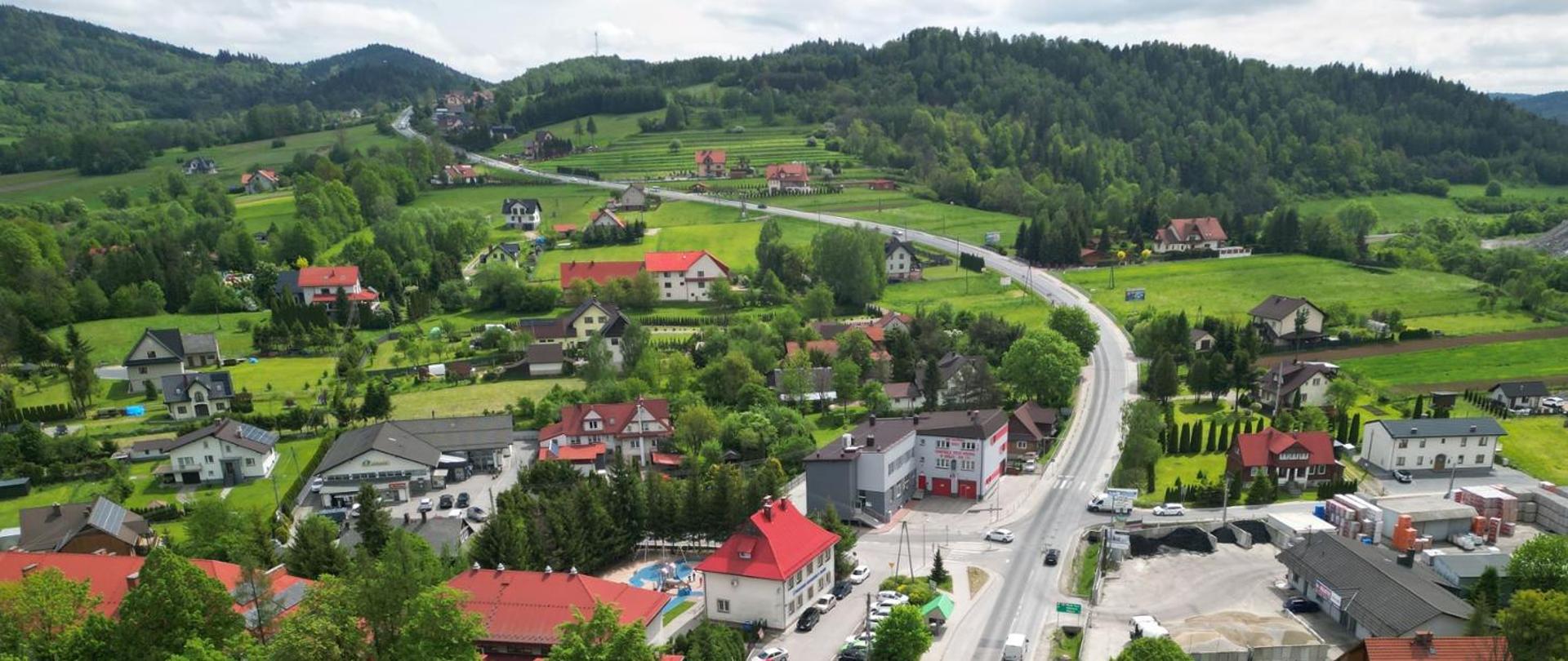 Widok z lotu ptaka na drogę przebiegającą przez górską miejscowość.