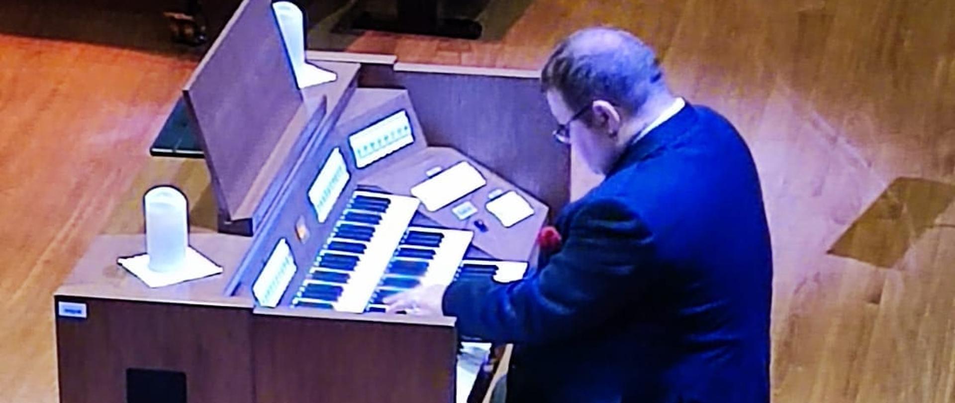 Mężczyzna gra na organach.