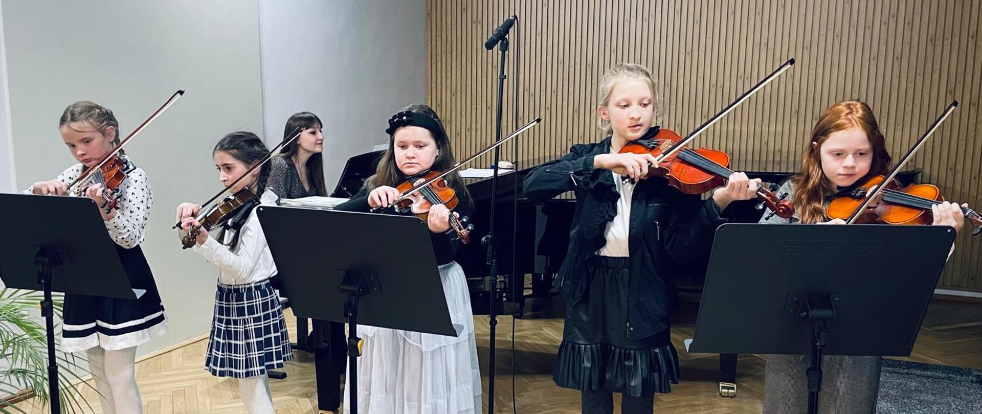 Galeria 15 zdjęć z koncertu duetów skrzypcowych, uczniowie grają na skrzypcach na scenie auli PSM w Kłodzku