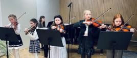 Galeria 15 zdjęć z koncertu duetów skrzypcowych, uczniowie grają na skrzypcach na scenie auli PSM w Kłodzku