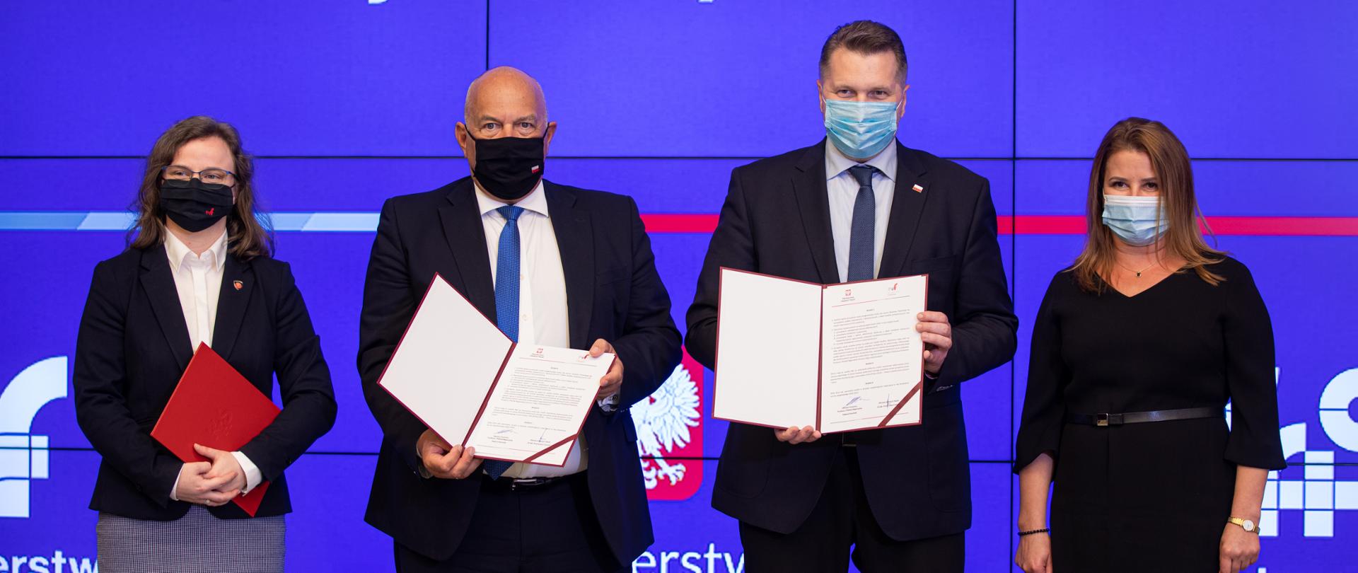 Minister Kościński i Minister Czarnek po podpisaniu listu intencyjnego na tle baneru MF i KAS