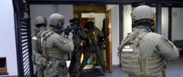 Uzbrojeni funkcjonariusze KAS wchodzą do domu podejrzanych