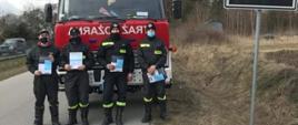 Zdjęcie przedstawia strażaków biorących udział w akcji dystrybucji ulotek dot. szczepień.