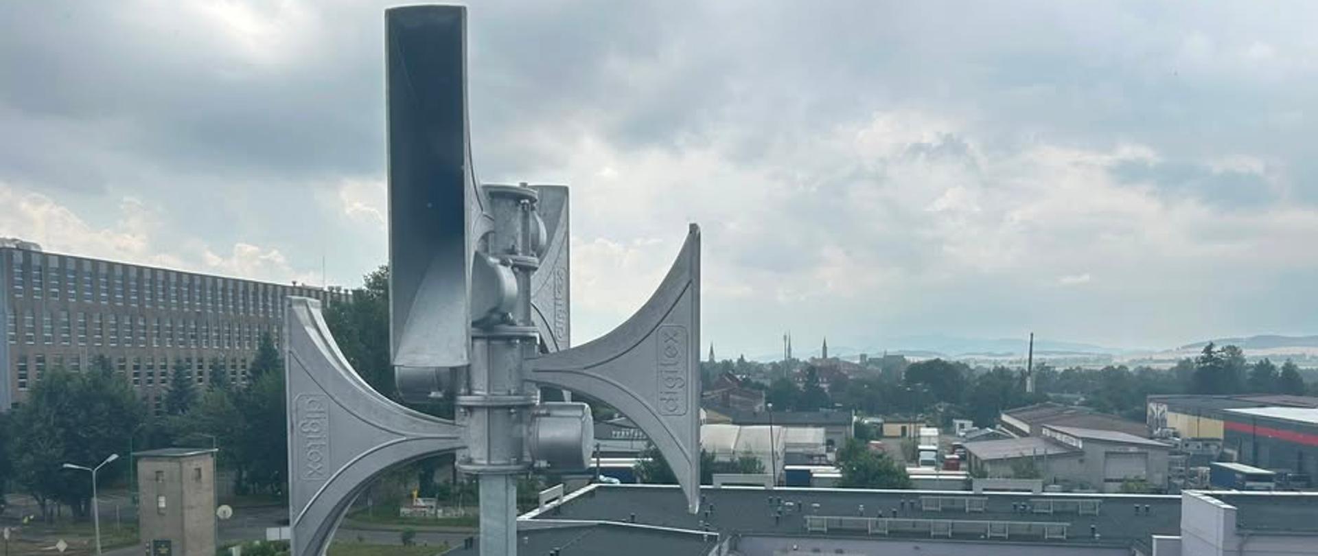 Zdjęcie przedstawia syrenę zamontowaną na dachu budynku. Informujemy, że Minister Spraw Wewnętrznych i Administracji wydał zarządzenie w sprawie przeprowadzenia krajowego ćwiczenia z zakresu ostrzegania i alarmowania o zagrożeniu uderzeniami z powietrza pod kryptonimem „ALARM-2026”.