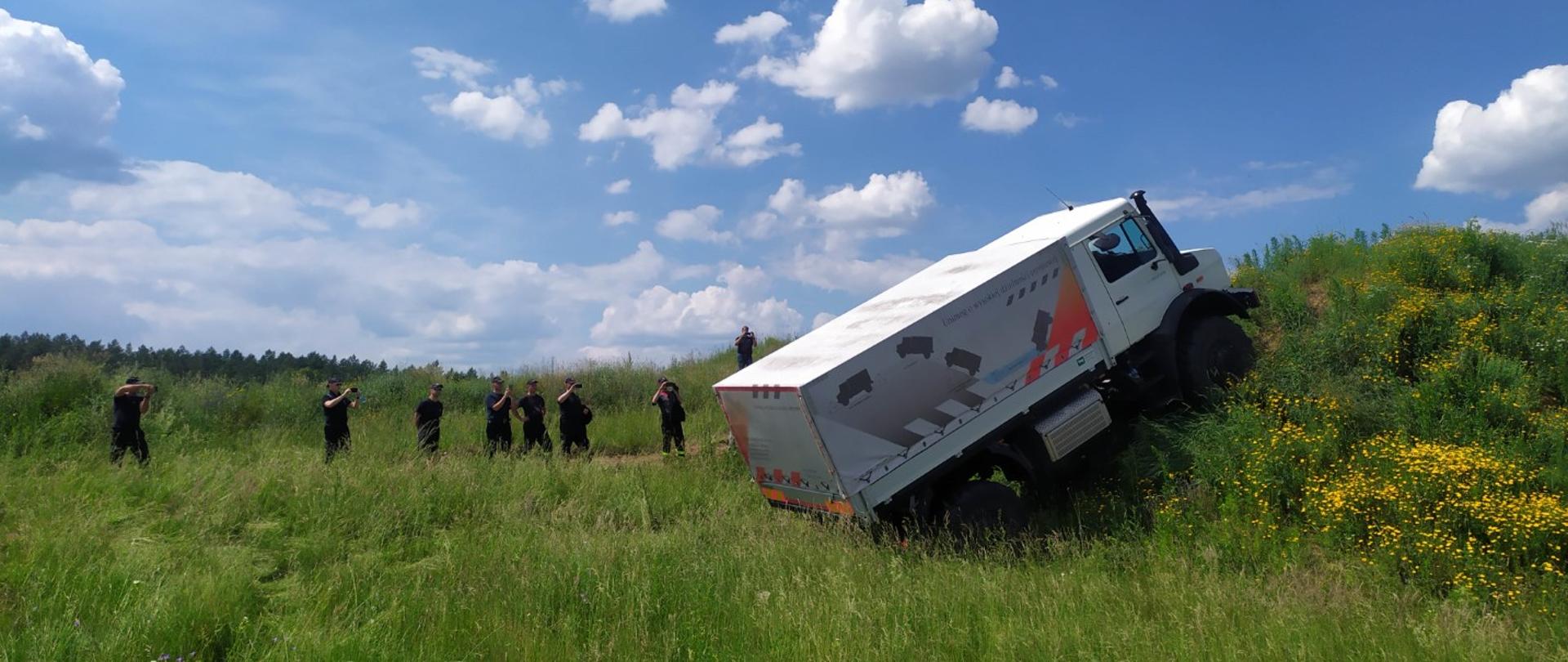 Zdjęcie przedstawia pojazd marki Mercedes w trakcie zajęć praktycznych szkolenia w zakresie kierowania pojazdami w trudnych warunkach terenowych