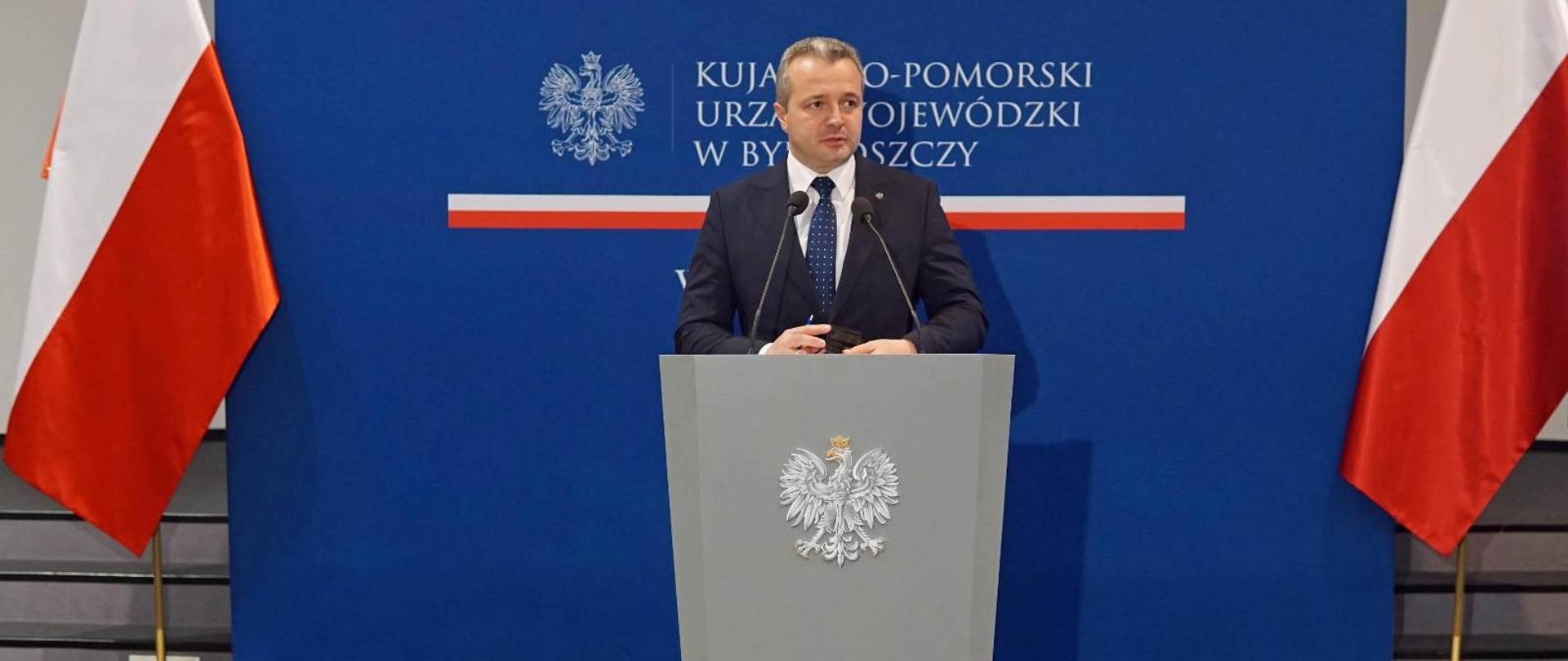 Jeden mężczyzna stojący przy mównicy i wypowiadający się 