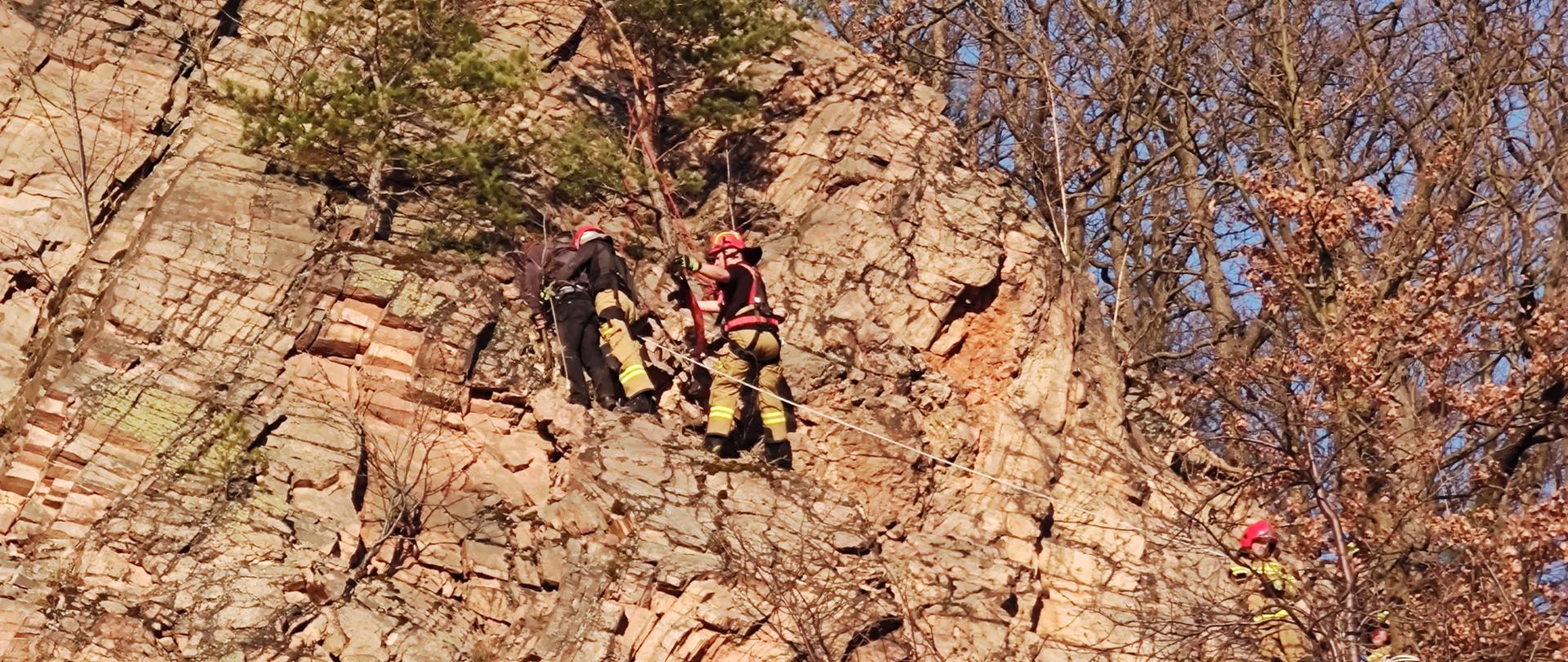 zbocze góry, na którym widać dwóch strażaków z linami w trakcie ewakuacji 