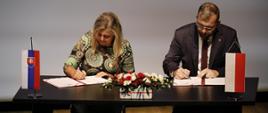 Podpisanie umowy o dofinansowaniu kultury w programie Interreg Polska-Słowacja 2021-2027, minister Grzegorz Puda siedzi przy stole i podpisuje umowę 