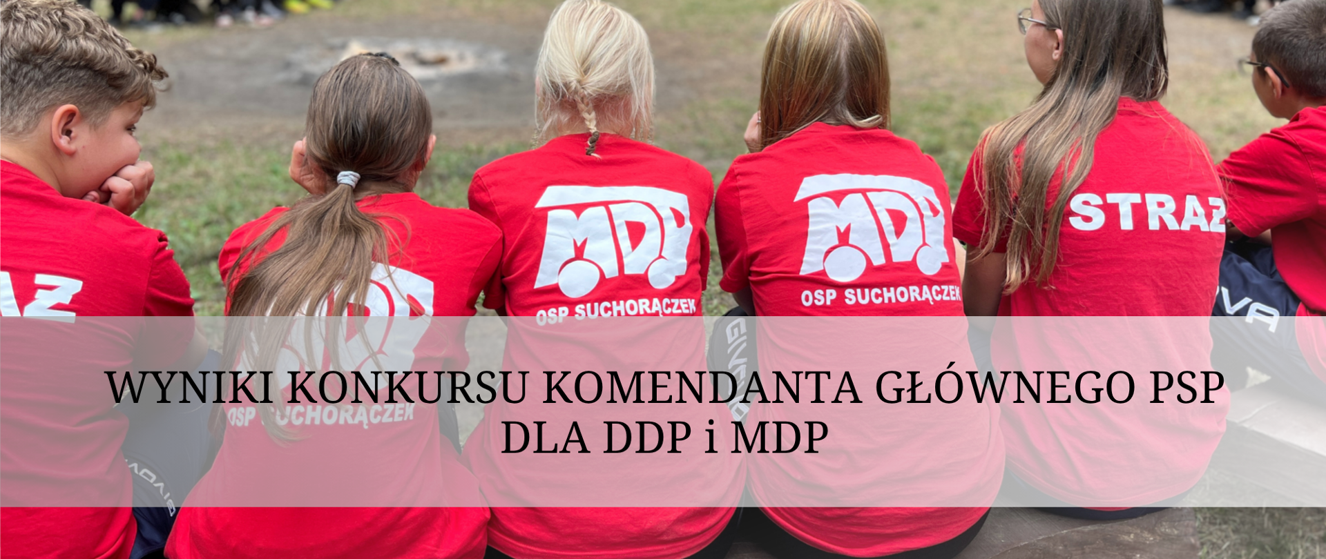 W szeregu, odwróceni plecami - młodzież w czerwonych koszulkach, z napisem MDP. 