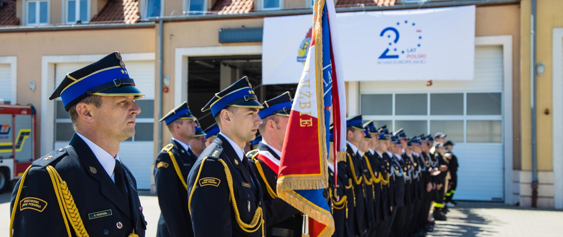 Zdjęcie pododdziału pożarniczego, na czele z dowódcą pododdziału, pocztem sztandarowym, funkcjonariuszami oraz druhnami i druhami OSP z powiatu szczycieńskiego 