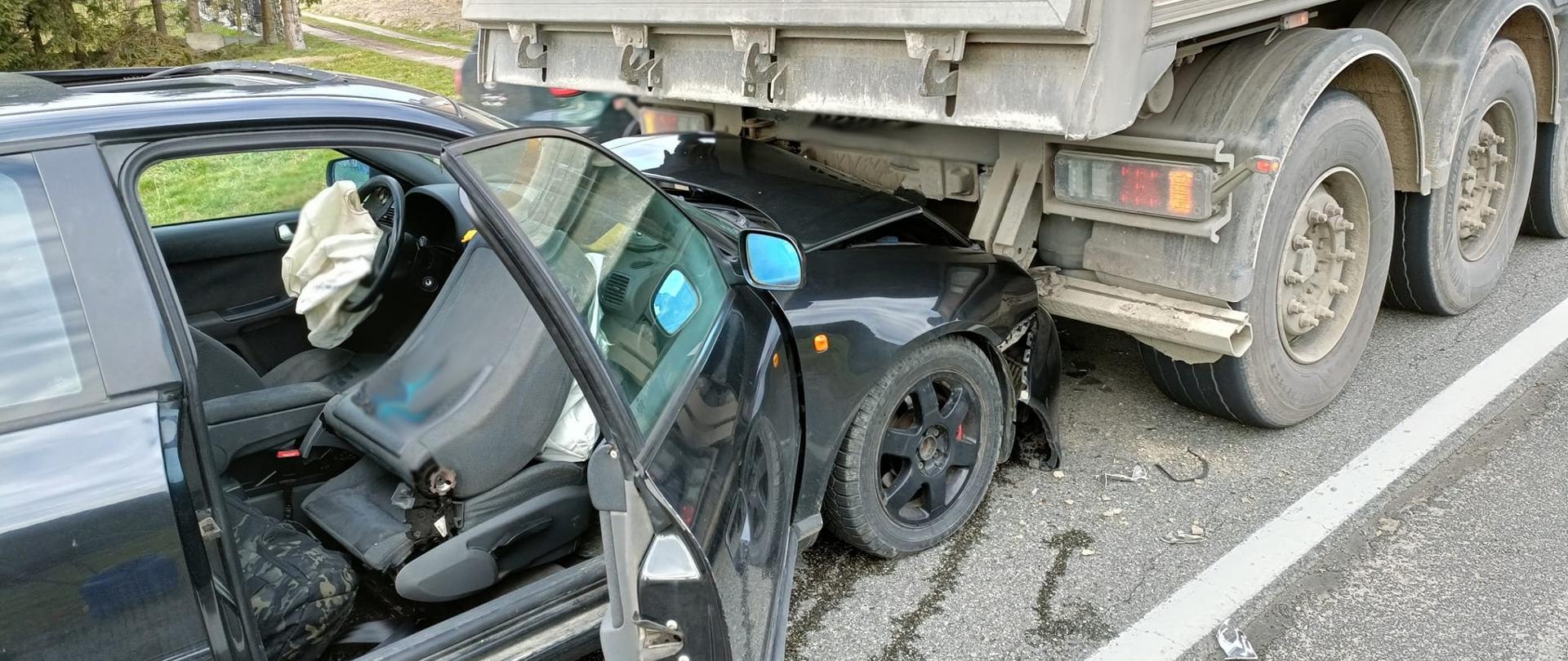 Samochód osobowy ciemnego koloru uderzył w tył samochodu ciężarowego