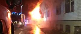 Widok strażaków gaszących stary budynek gminy