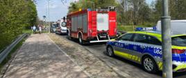 Na zdjęciu czerwone samochody strażackie, karetka pogotowia ratunkowego oraz Policja