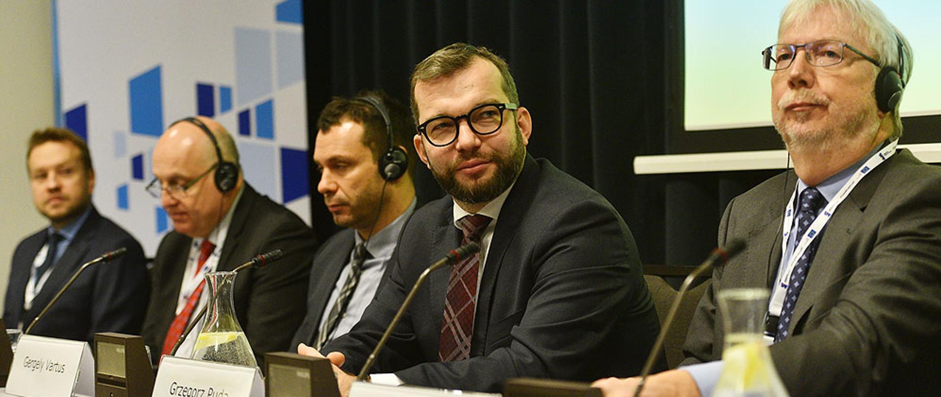 uczestnicy panelu siedzą przy stole, wśród nich wiceminister Grzegorz Puda