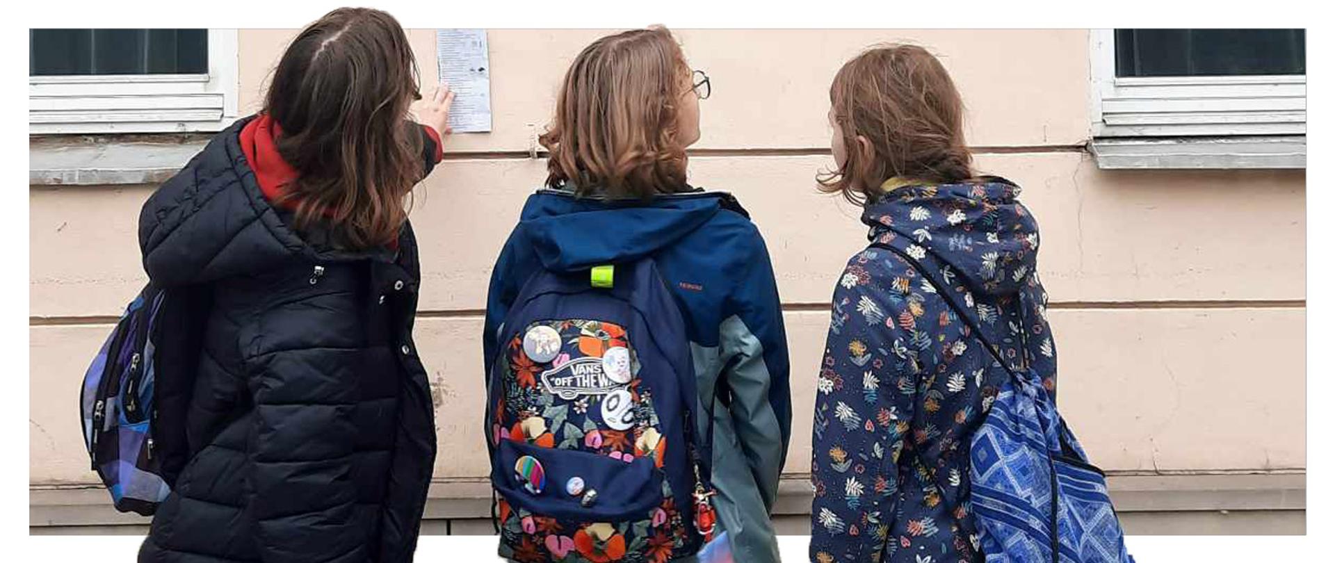 Uczniowie podczas gdy terenowej pt. Śladami Powstania Warszawskiego organizowanej przez Muzeum Niepodległości w Warszawie oraz Fundację Questingu.
Zdjęcie przedstawia trójkę uczennic biorącą udział w grze.