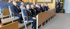 Uczestnicy konferencji siedzą w sali wykładowej Uniwersytetu Jana Długosza w Częstochowie. W pierwszych rzędach widoczni są przedstawiciele Państwowej Straży Pożarnej w mundurach wyjściowych oraz pozostali goście wydarzenia. Wszyscy słuchają prelekcji z dużym zainteresowaniem