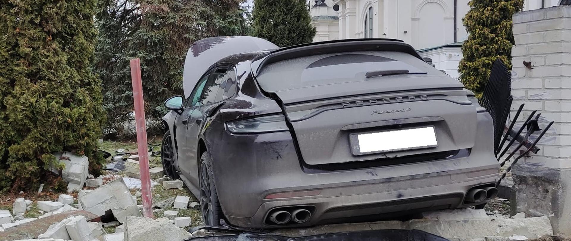 Samochód Porsche biorący udział w wypadku, w oddali budynek Kościoła. 