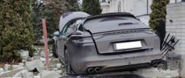 Samochód Porsche biorący udział w wypadku, pojazd uderzył w ogrodzenie placu plebanii.