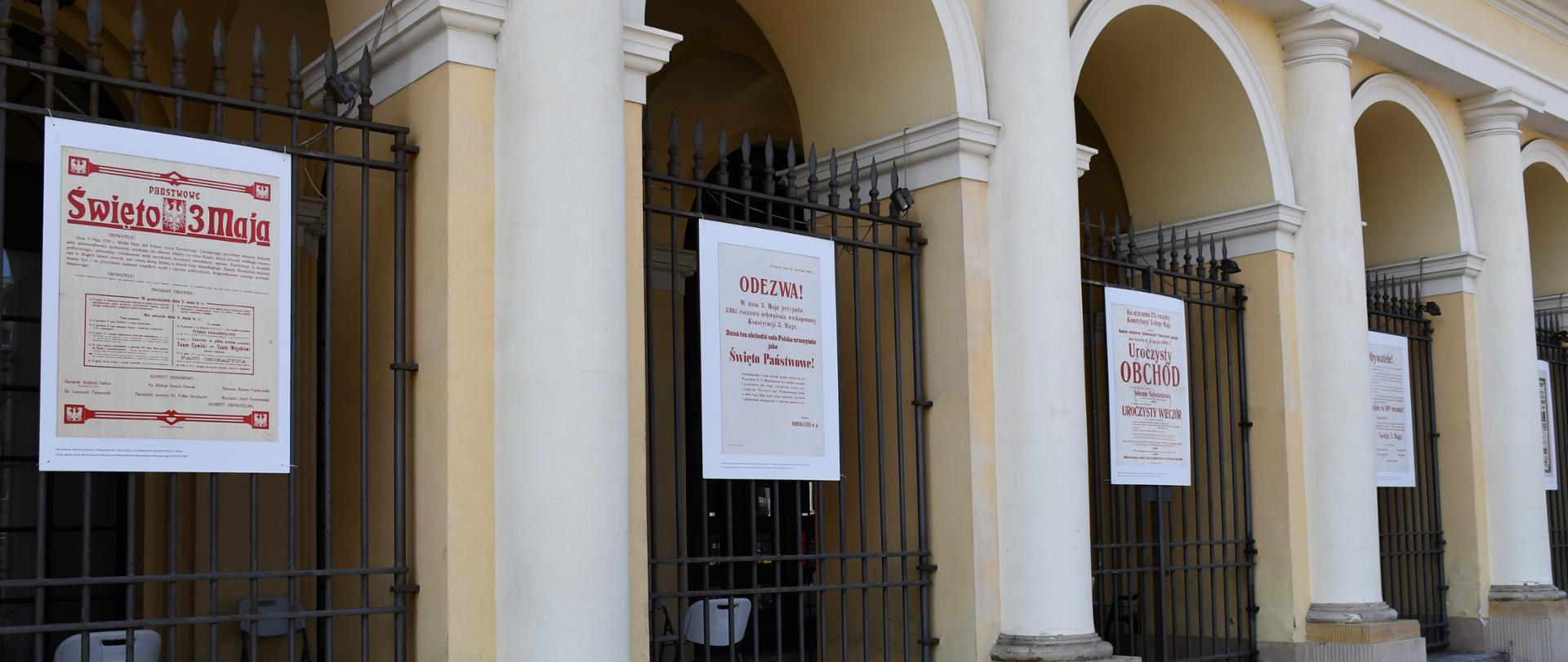 Zdjęcie przedstawia kilka planszy, które składają się na wystawę pod tytułem: „Uchwalenie Konstytucji 3 Maja - obchody rocznicowe w Przemyślu". Wystawa ta znajduje się w podcieniach Mazowieckiego Urzędu Wojewódzkiego w Warszawie.