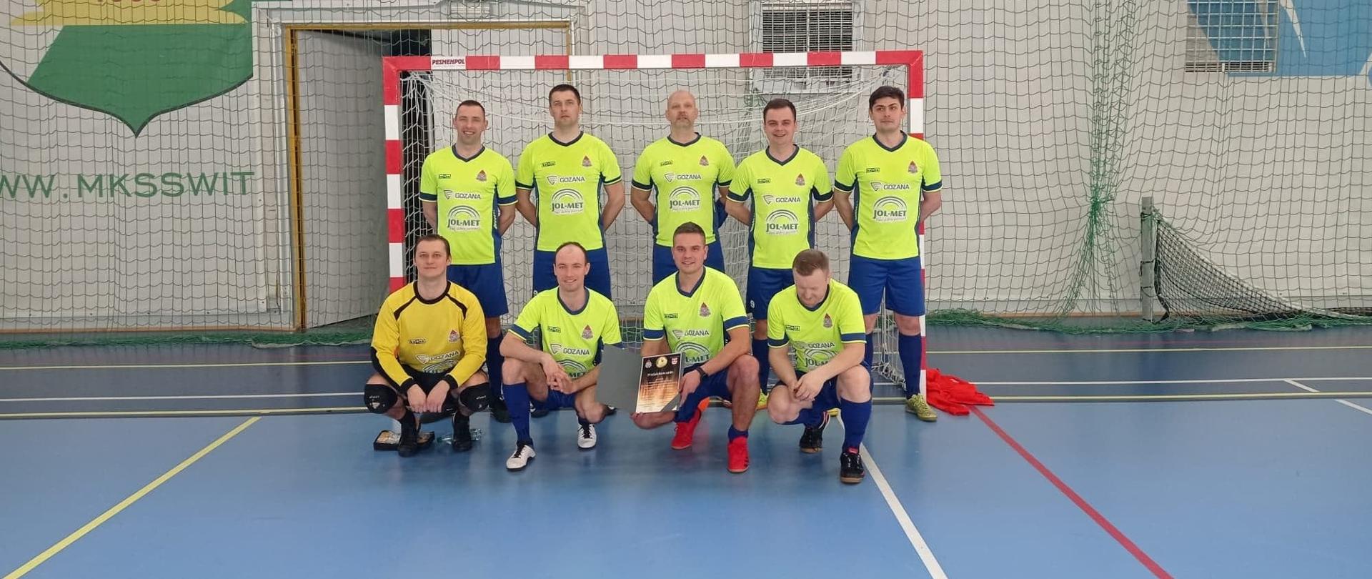 Piłkarze pozują przed bramką z dyplomem.