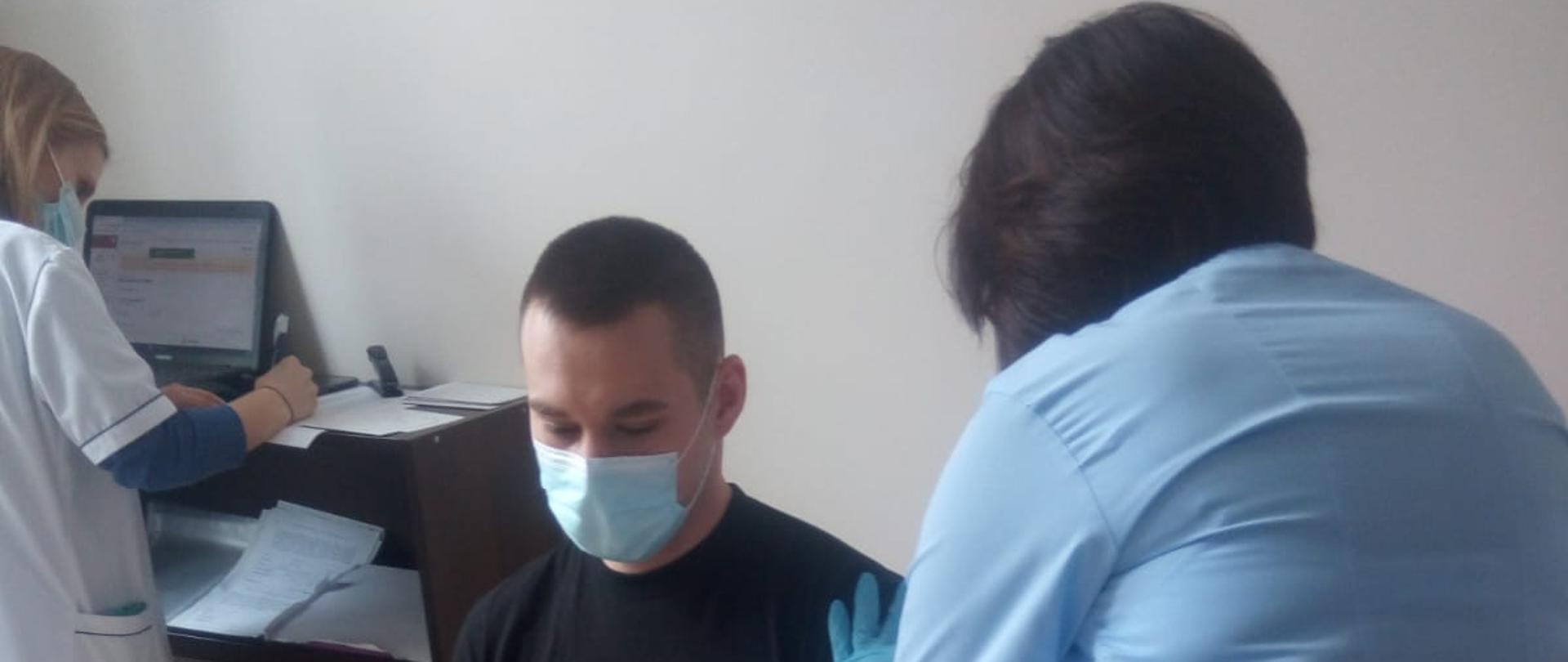 Strażacy w gabinecie zabiegowym otrzymują szczepionkę przeciw COVID-19