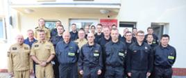 Strażacy oraz zaproszeni goście stoją obok siebie.