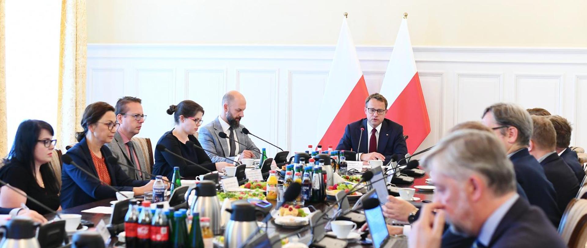 Pan Minister Marcin Romanowski, wraz z członkami Rady przy stole podczas posiedzenia.