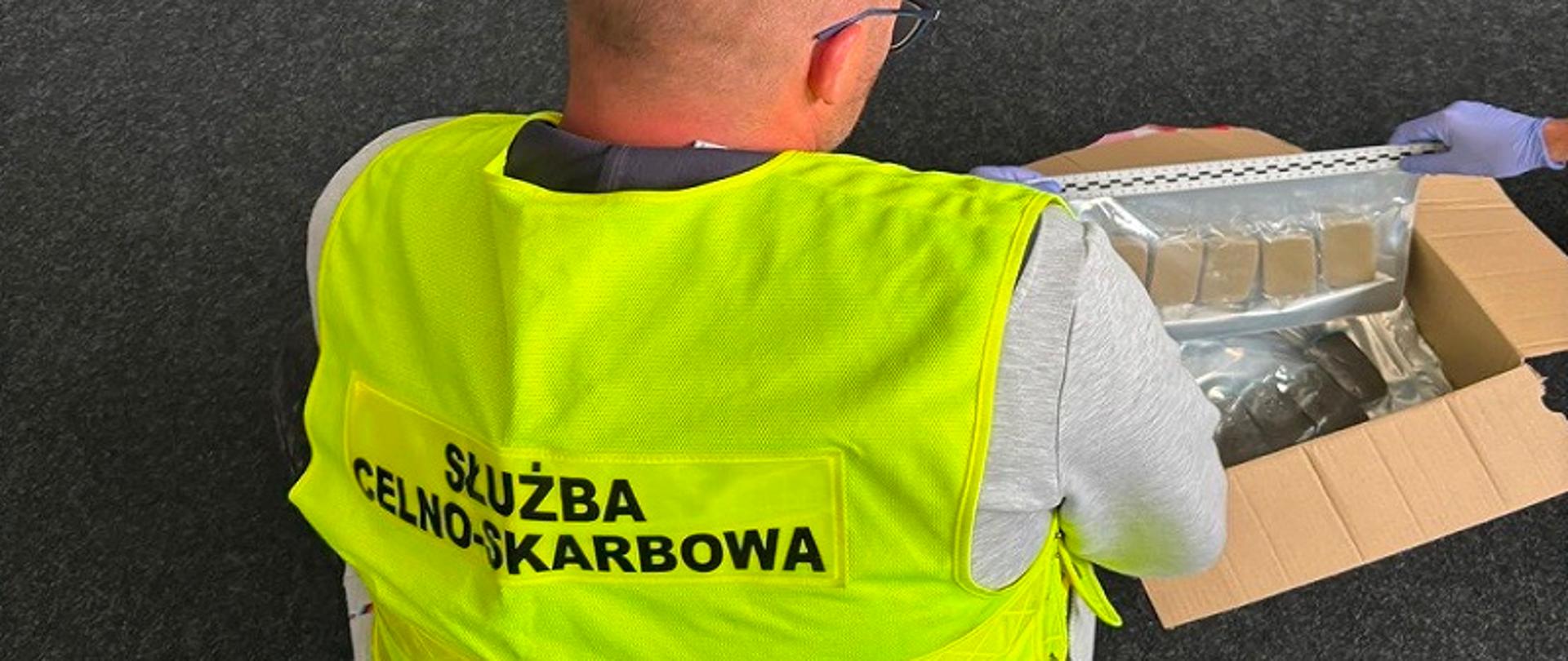 Funkcjonariusz ogląda zajęte narkotyki. 