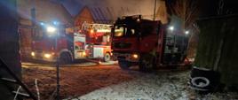 Na zdjęciu pole sprzętowe do aparatów powietrznych. W tle widać dwa samochody pożarnicze a za nimi część budynku objętego pożarem. Jest pora nocna, strażacy oświetlają teren działań.