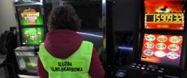 Funkcjonariuszka Służby Celno-Skarbowej na tle zatrzymanych automatów do gier hazardowych