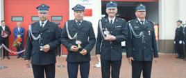 Jubileusz 95-lecia OSP Konary. Plac przed remizą strażacką. W szeregu, na tle budynku stoją uhonorowani statuetkami członkowie zarządu miejscowej OSP wraz z jej prezesem.