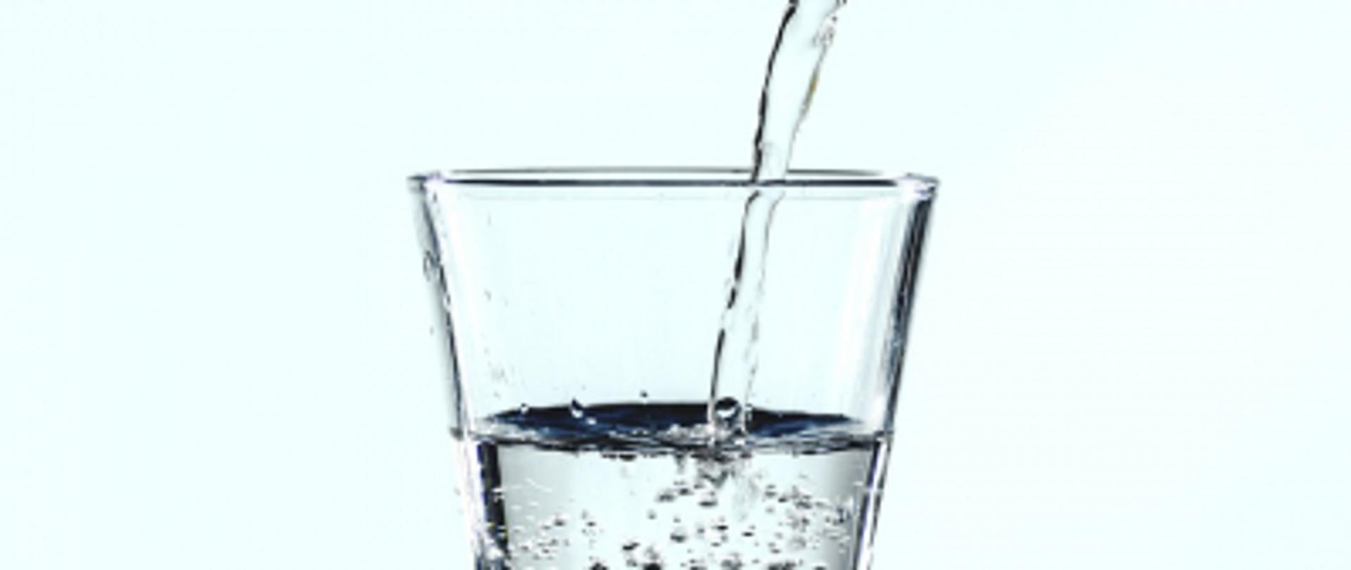 Szklanka, do której wlewana jest czysta woda