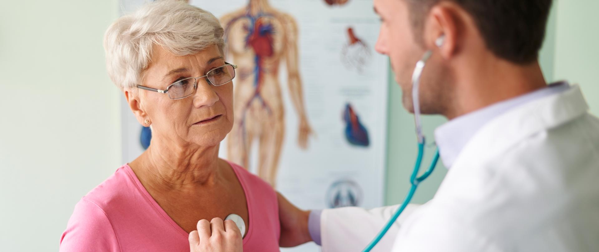 lekarz badający starszą kobietę stetoskopem