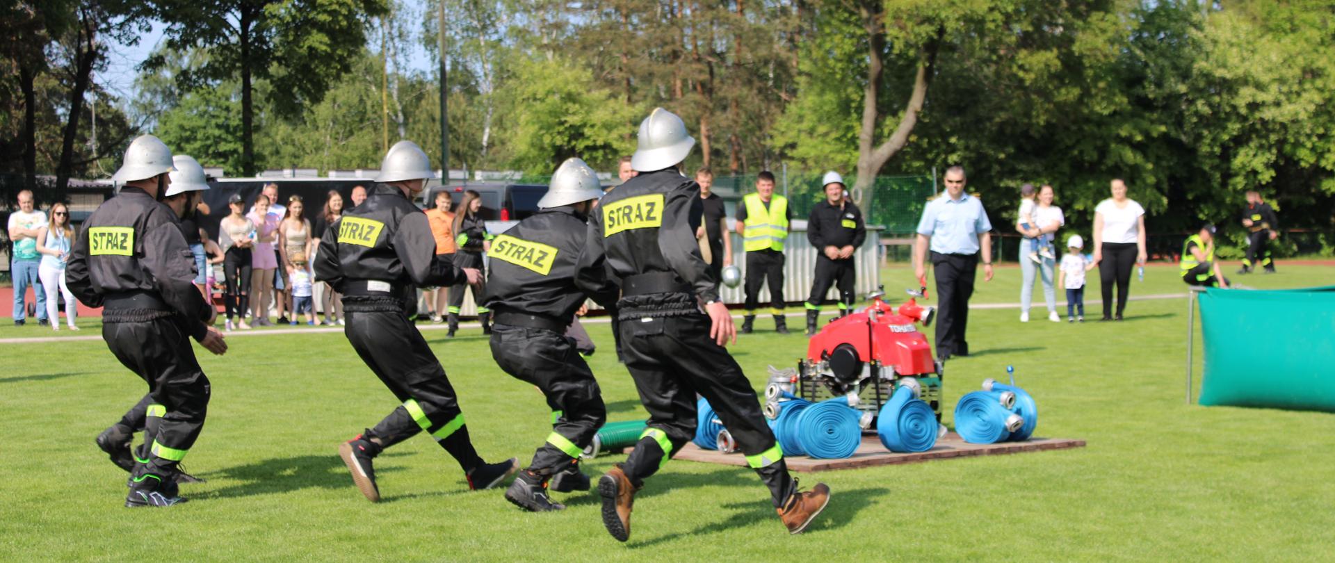 Strażacy w trakcie rozwinięcia bojowego podczas powiatowych zawodów sportowo-pożarniczych OSP