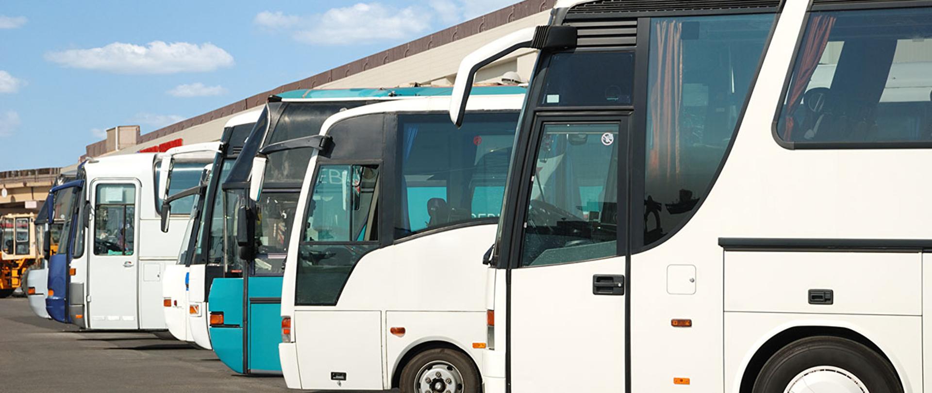 Na zdjęciu widać stojące na parkingu autobusy turystyczne