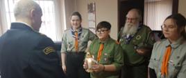 Na zdjęciu widać harcerzy przekazujących Betlejemskie Światło Pokoju Komendantowi Powiatowemu PSP 