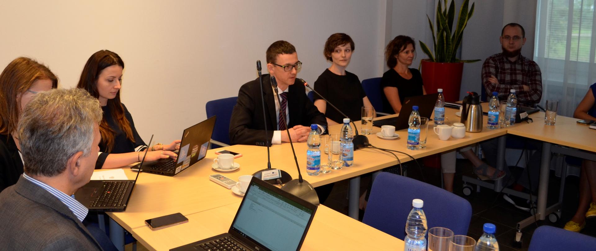 Pierwsze spotkanie grupy roboczej ds. otwartości danych. Ludzie siedzą przy stołach.