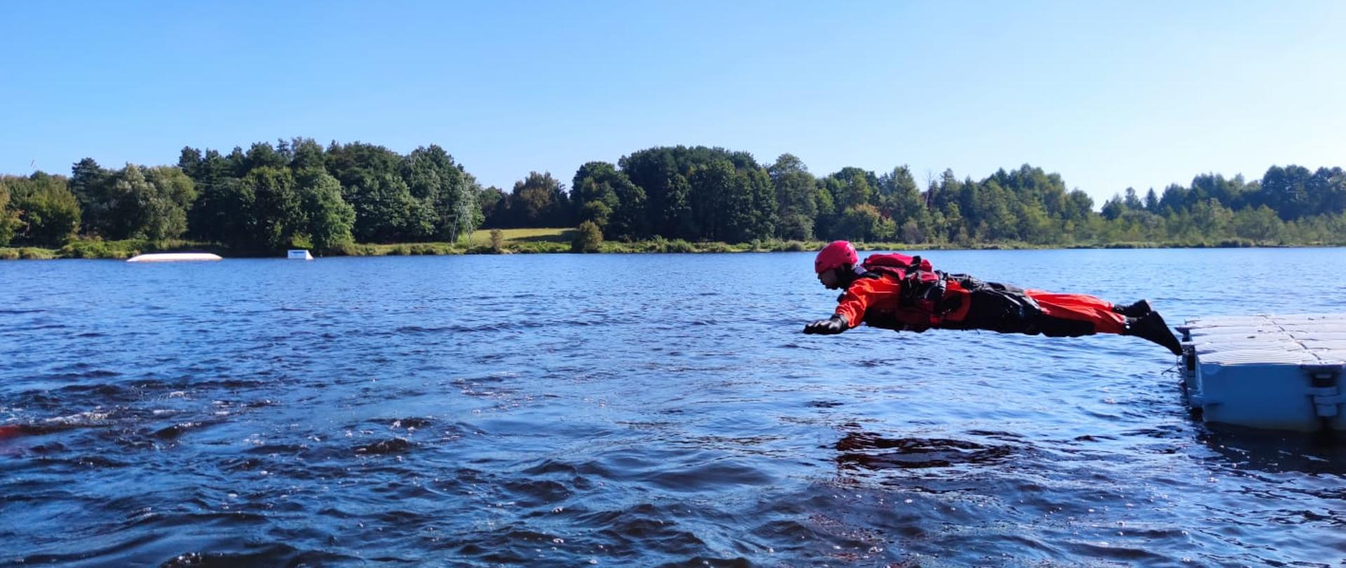 Strażak ćwiczy ratowniczy skok do wody