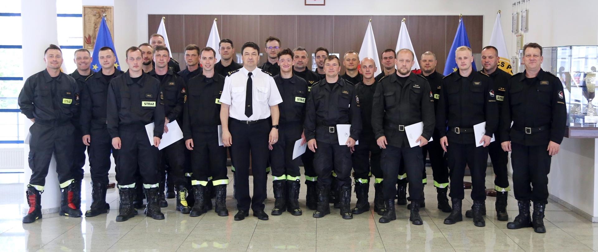 Grupowe zdjęciu uczestników oraz instruktorów warsztatów (22 osoby) w towarzystwie Komendanta Centralnej Szkoły PSP oraz naczelnika wydziału nauczania