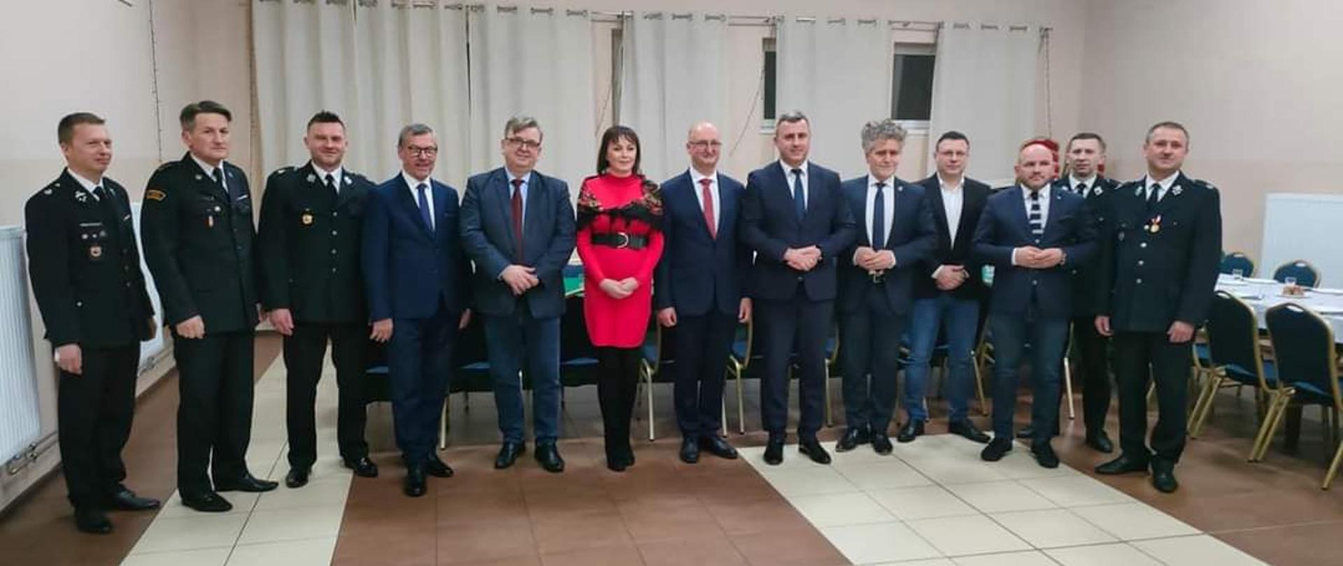 Zdjęcie przedstawia gospodarzy oraz zaproszonych gości podczas spotkania noworocznego w Ochotniczej Straży Pożarnej w Sukowie