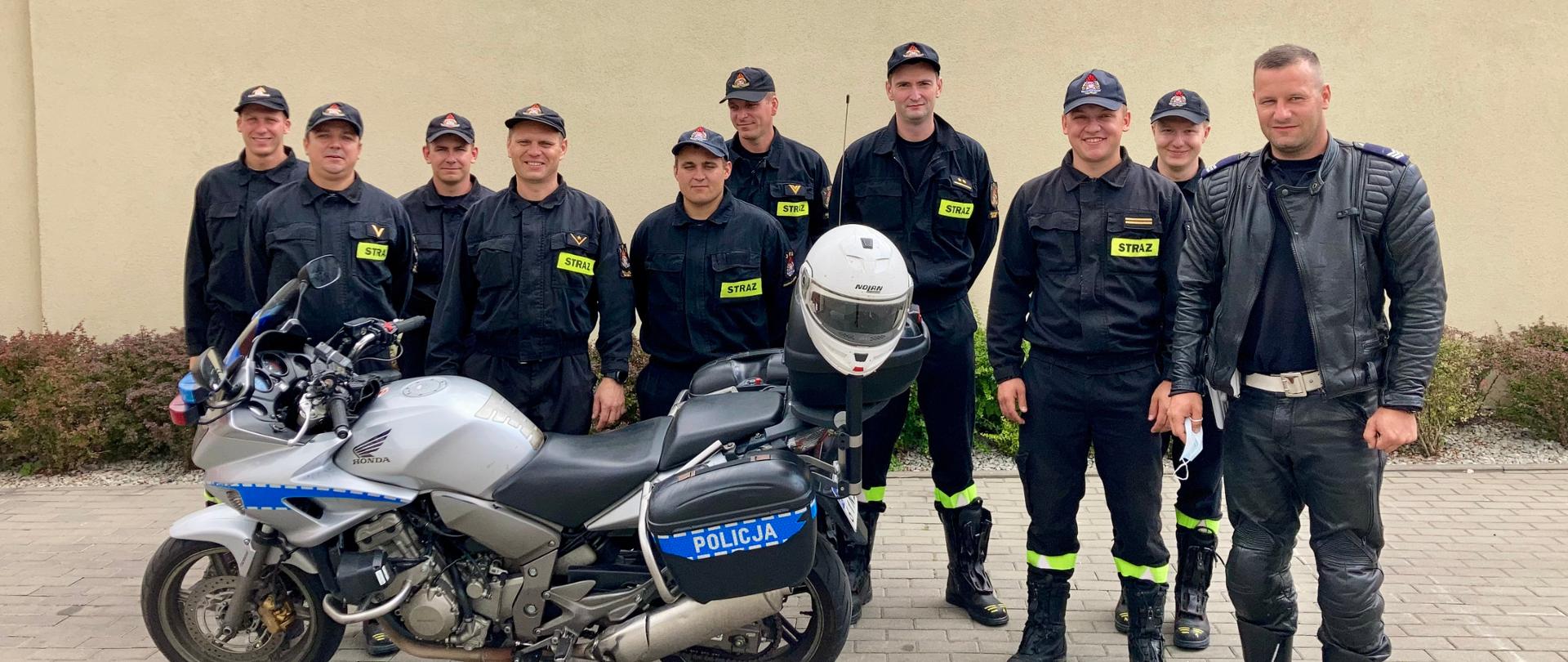 Zdjęcie przedstawia uczestników szkolenia, prowadzącego, motocykl policyjny