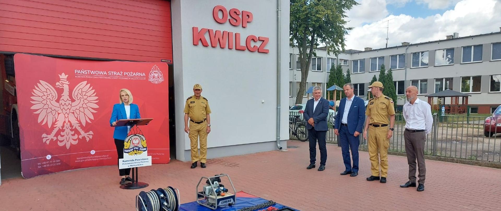 Na pierwszym planie przekazywany sprzęt, w tle zaproszeni goście.