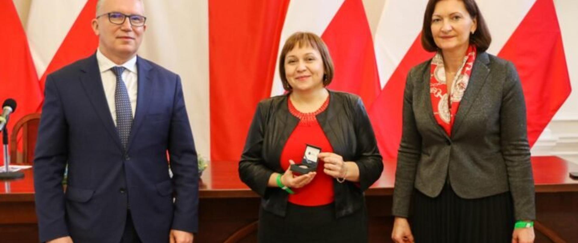 Wojewoda podkarpacki Ewa Leniart oraz Dyrektor Oddziału Okręgowego Narodowego Banku Polskiego w Rzeszowie Jerzy Guniewski podczas uroczystego przekazania pamiątkowych monet z napisem „Dziękujemy służbie zdrowia za poświęcenie w czasie pandemii COVID-19”. W środku jedna z uhonorowanych osób -Barbara Stawarz – dyrektor Wojewódzkiego Szpitala im. Św. Ojca Pio w Przemyślu. 