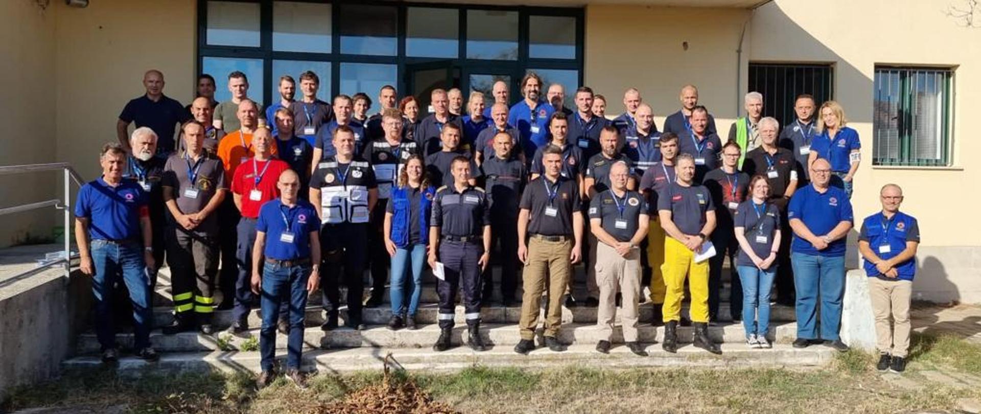 zdjecie grupowe strażaków z polski i chowracji w tle budynek