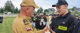Komendant Powiatowy PSP w Ropczycachwręcza puchar za II miejsce dla OSP Kozodrza