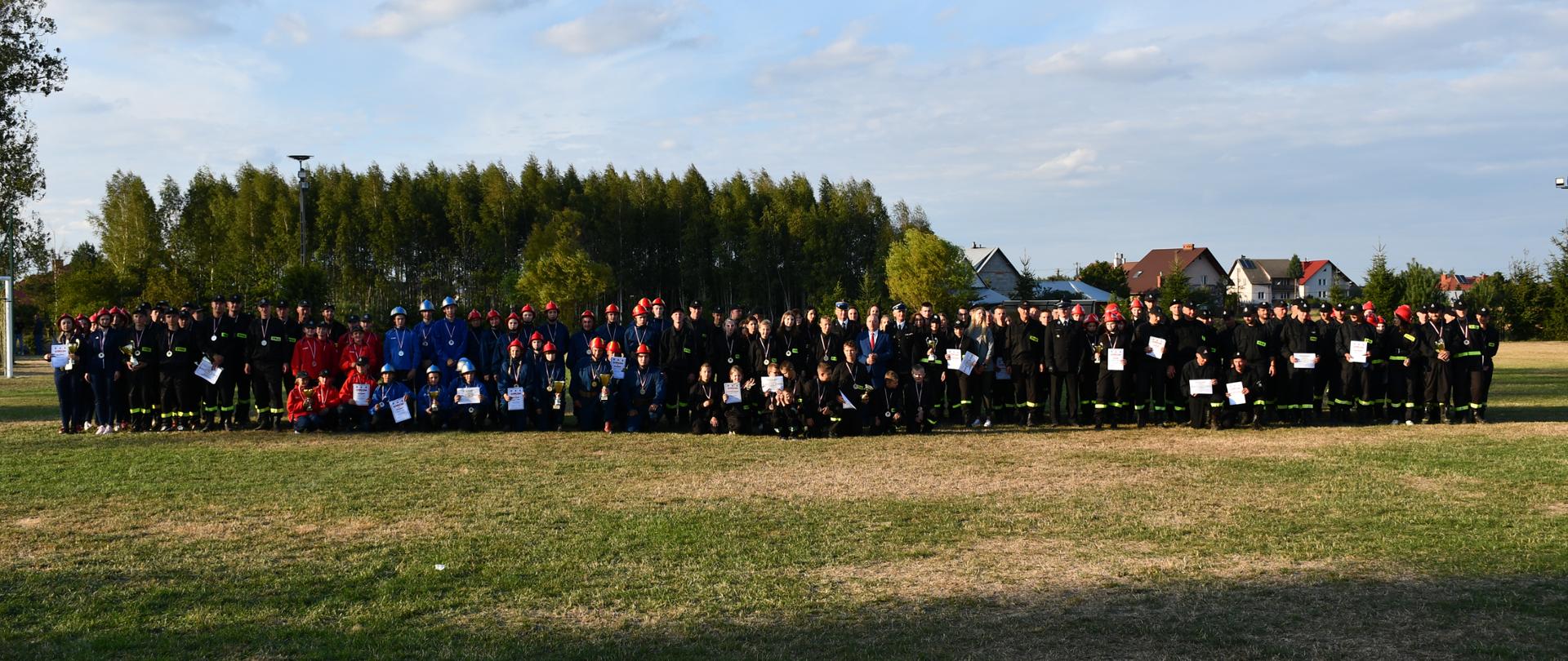 Na zdjęciu widzimy wszystkich uczestników zawodów wraz z zaproszonymi gośćmi pozującymi do zbiorowego zdjęcia.