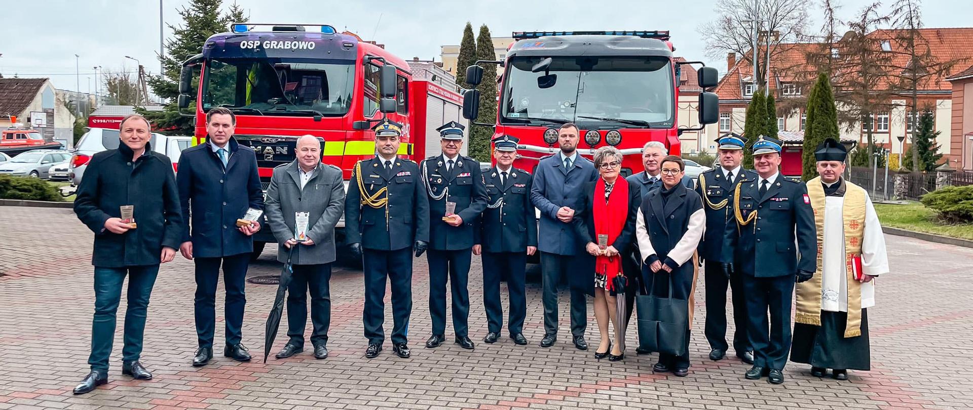 Goście zebrani przed samochodami strażackimi